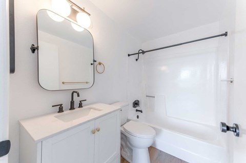 A white bathroom with a sink, toilet, and bathtub.