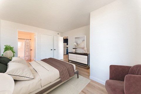 a bedroom with a bed and a dresser and a chair