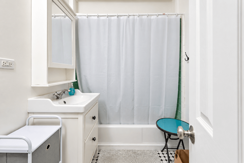 A white bathroom with a white sink and a white toilet.