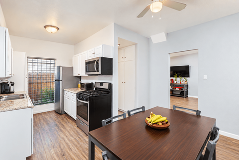 A kitchen with a table and chairs and a bowl of bananas on it.