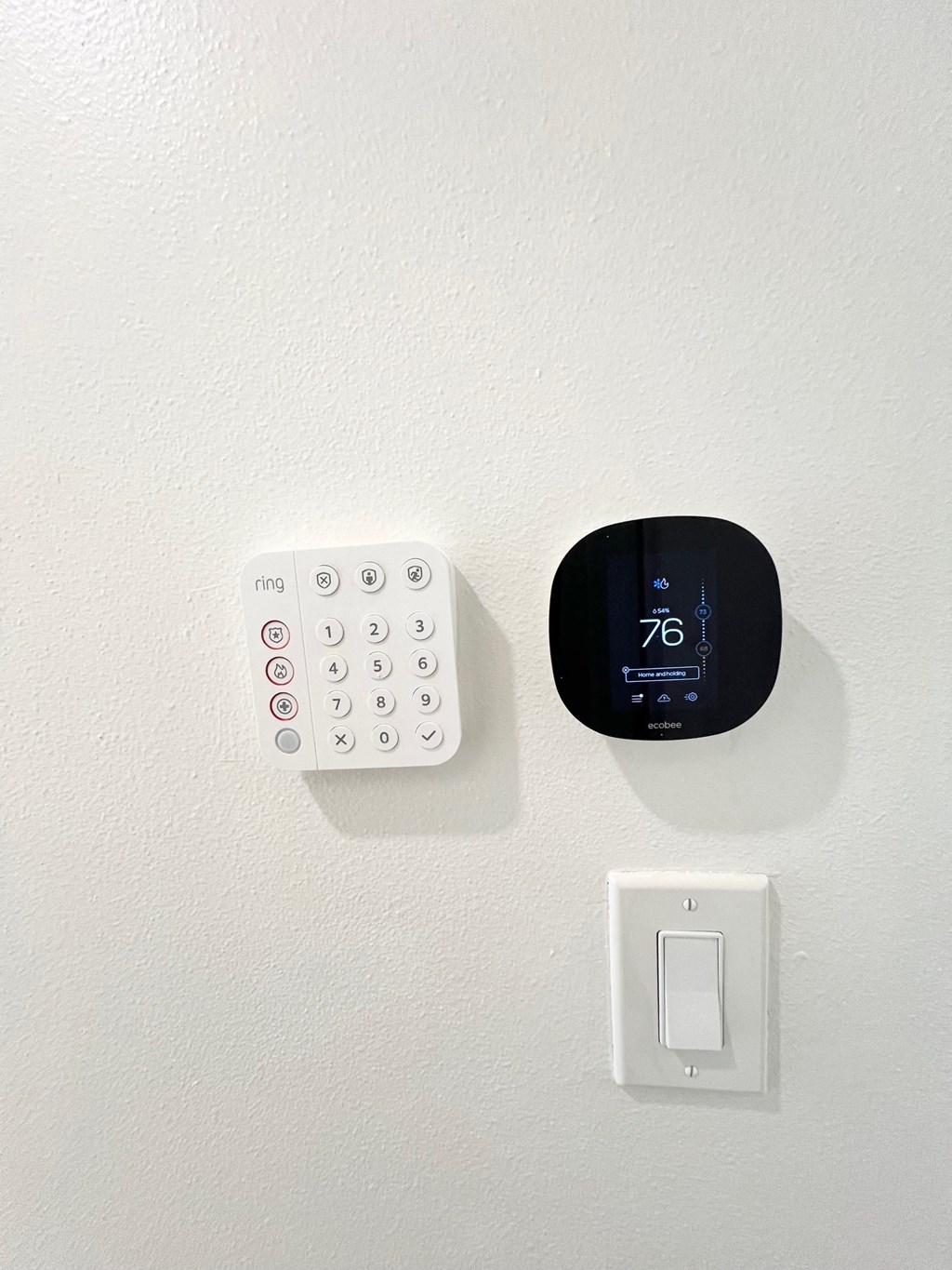 a clock and a remote control sitting on a wall