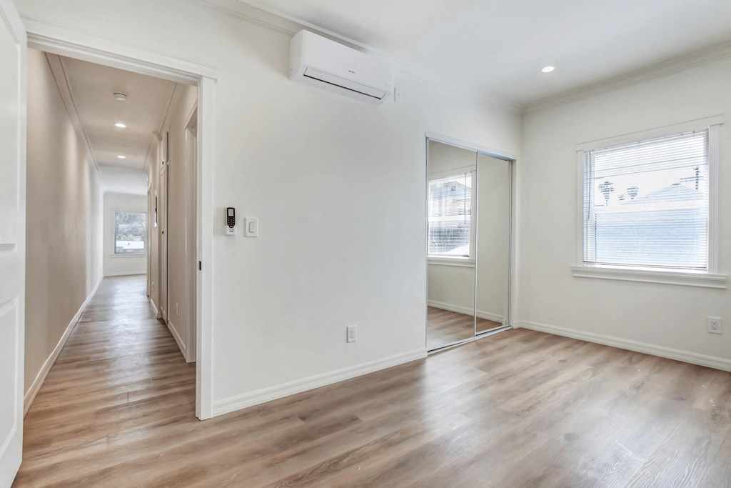 an empty living room with white walls and wood floors