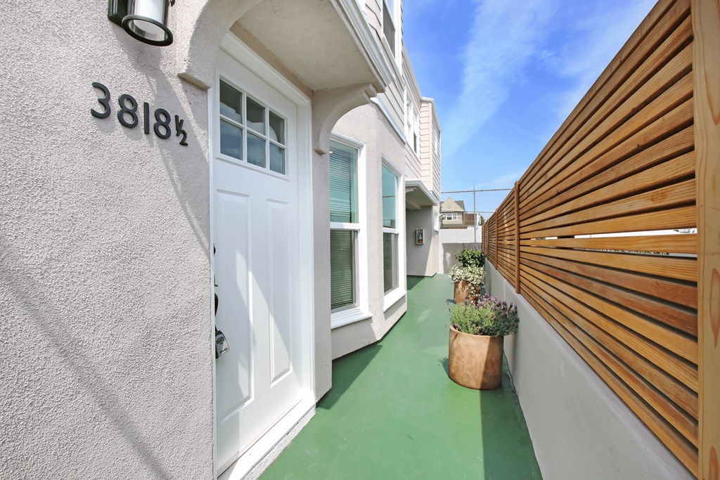 the entrance to a house with a white door and a wooden fence