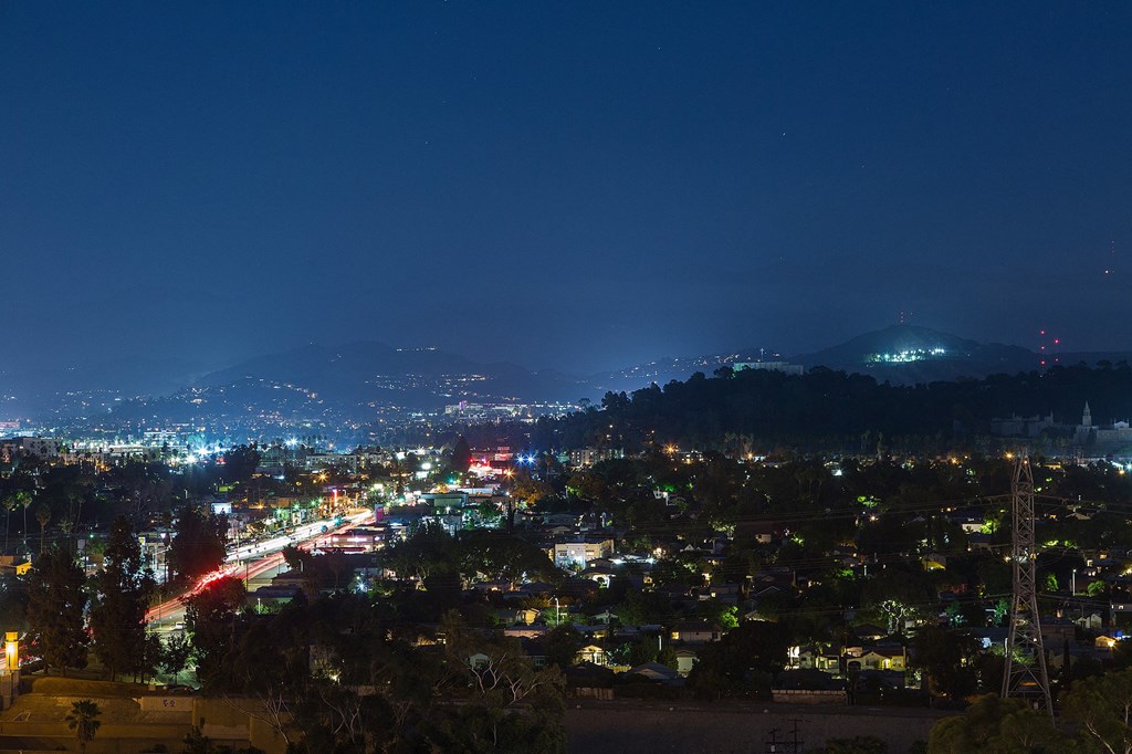 a view of a city at night from a hill