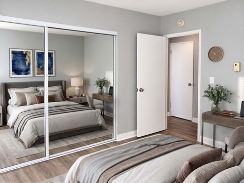 A bedroom with a large bed and a mirrored wardrobe.