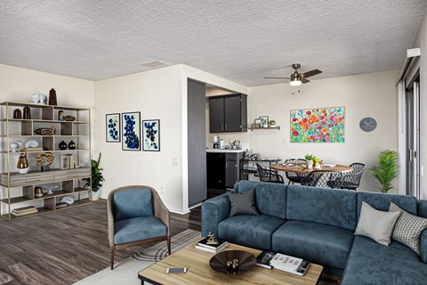 A living room with a blue couch and a chair.