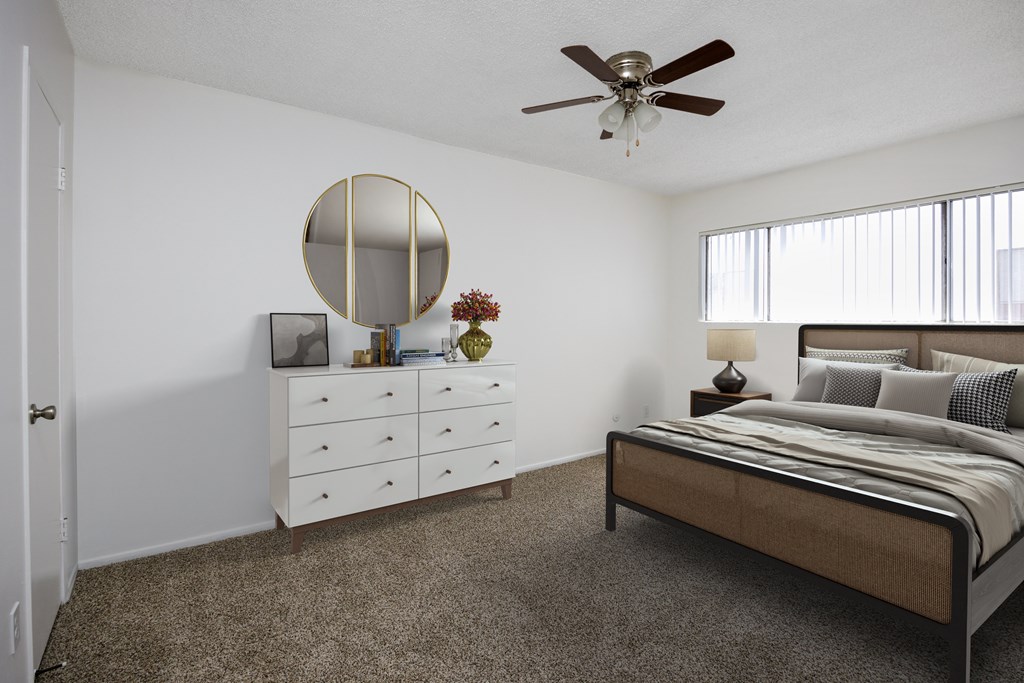 a bedroom with a bed and a white dresser and a ceiling fan