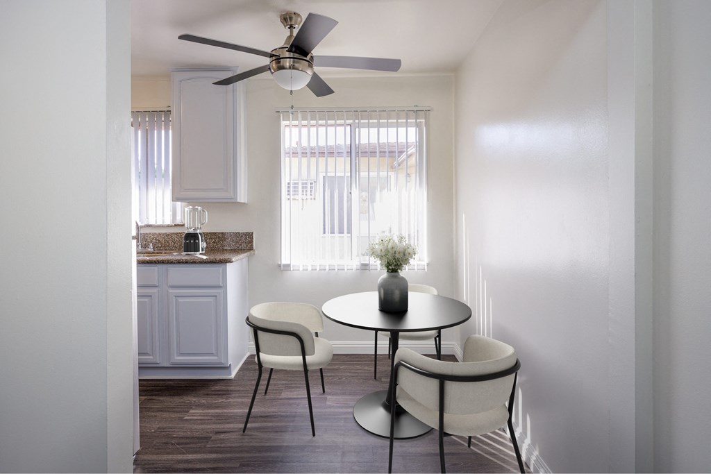 a kitchen and dining area with a table and chairs and a ceiling fan
