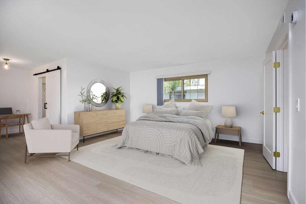 a white bedroom with a bed and a white rug