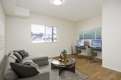 a living room with a couch and a desk with a computer