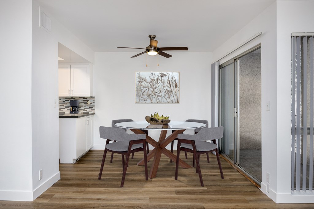 a dining room with a table and chairs and a ceiling fan