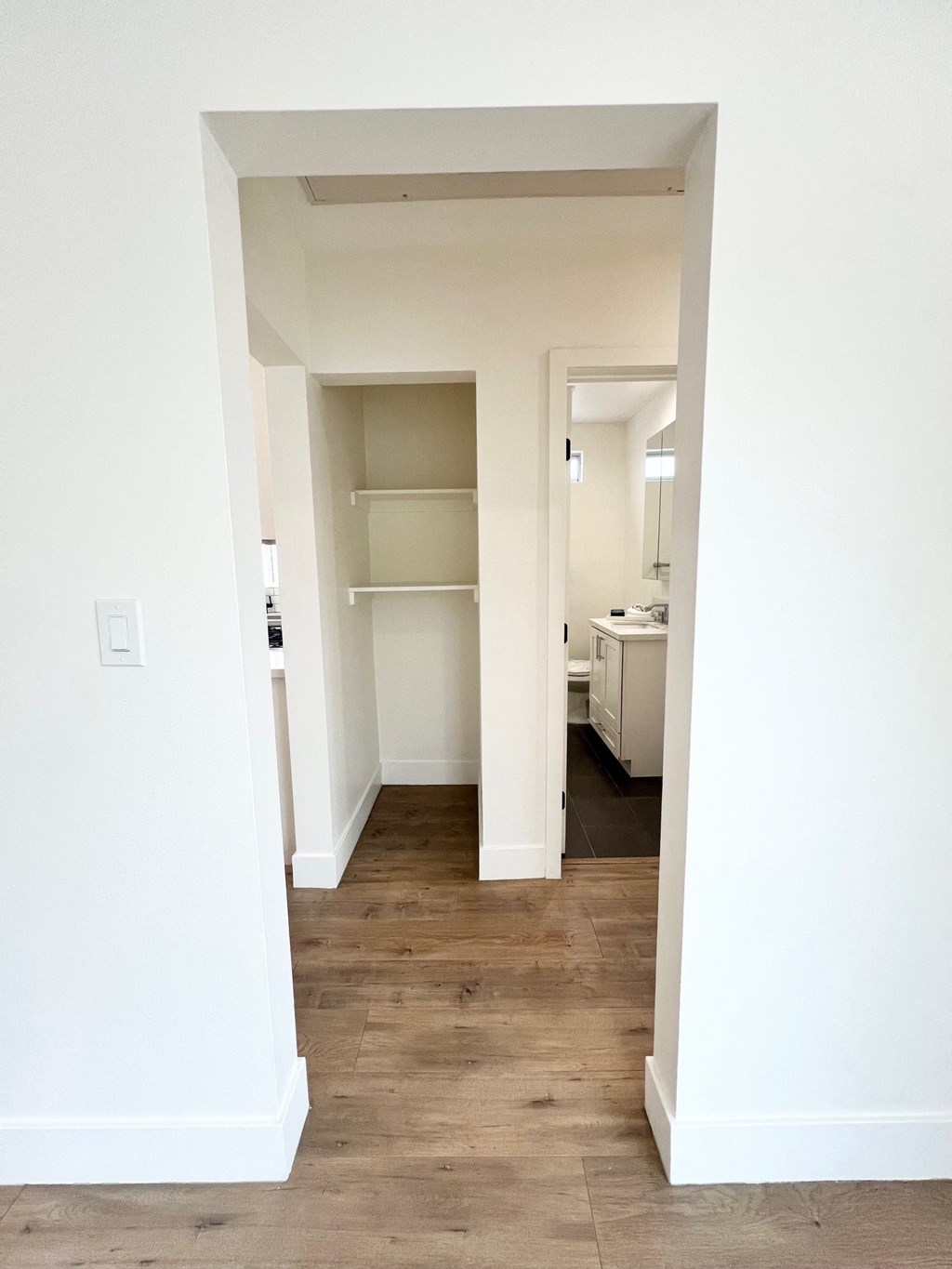 a renovated living room with white walls and a wood floor