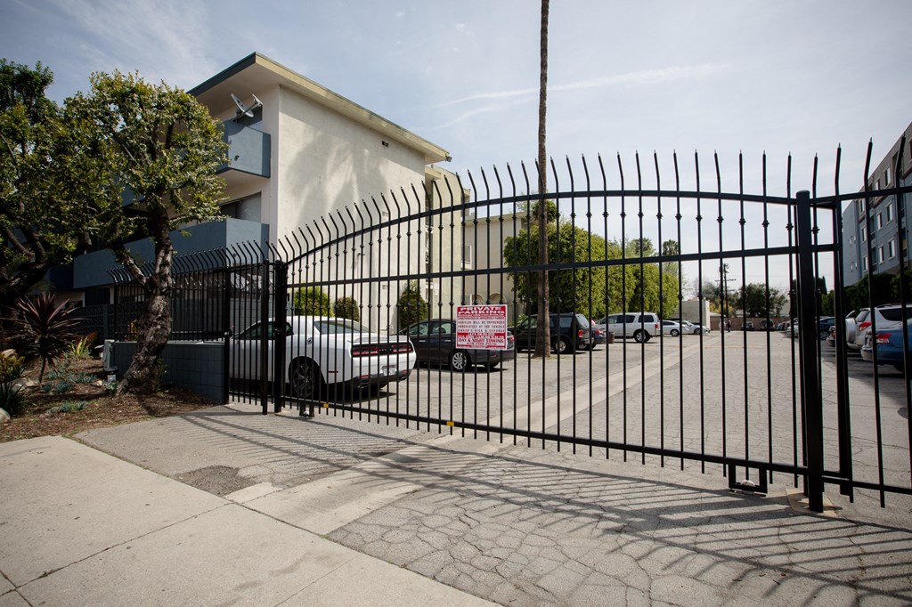 a gate with cars parked in front of a building