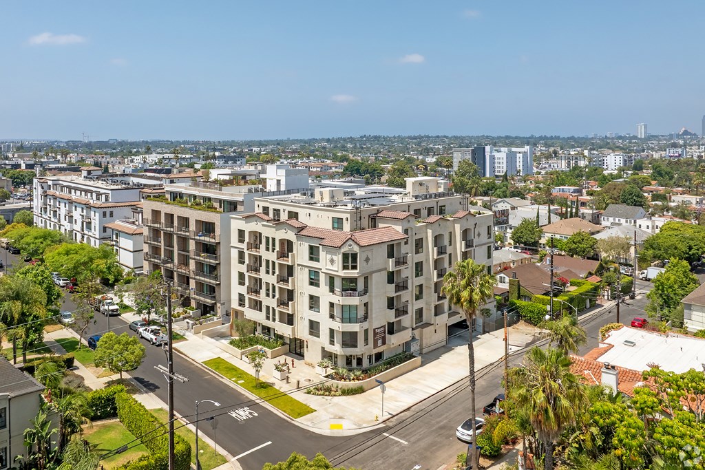 A large apartment building with a parking lot in front of it.