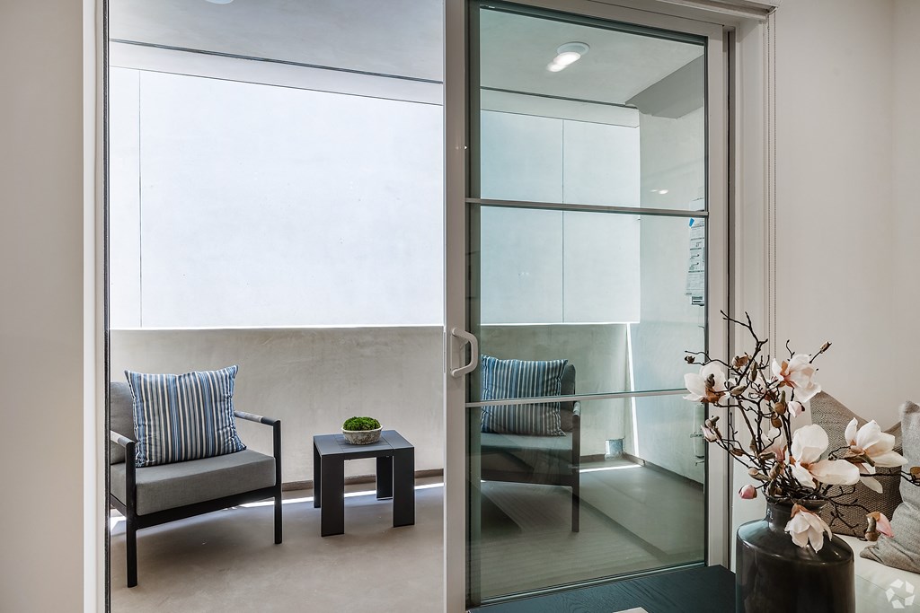 A living room with a couch, chair, and a table with a bowl on it.