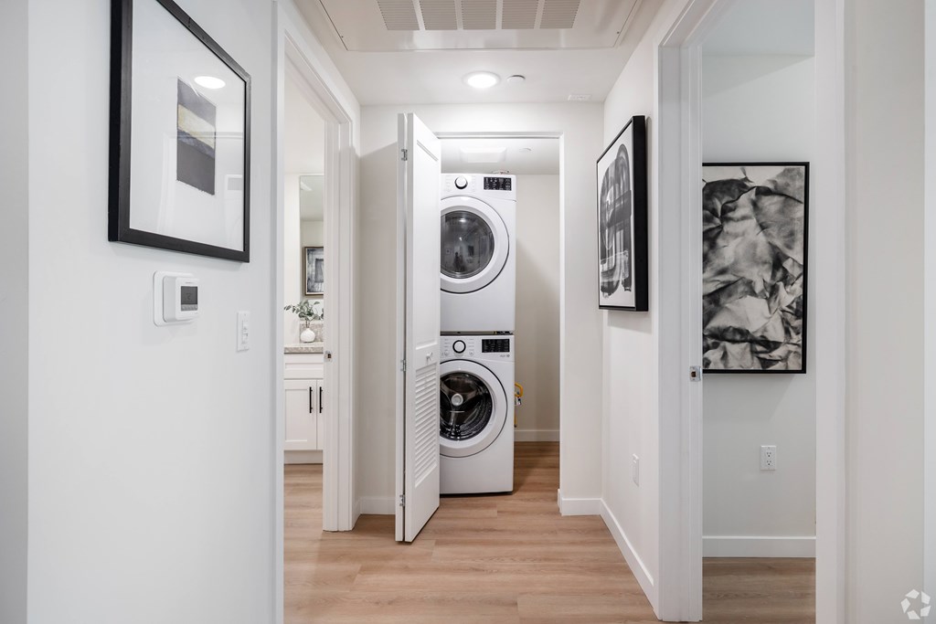 A white laundry room with a washer and dryer stacked on top of each other.