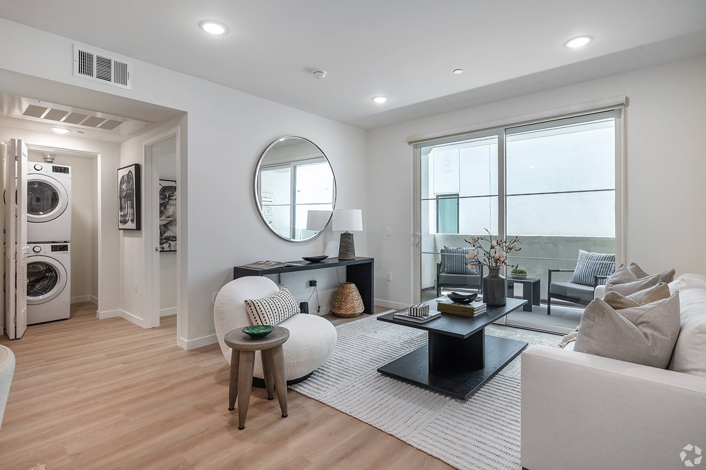A modern living room with a washer and dryer built into the wall.