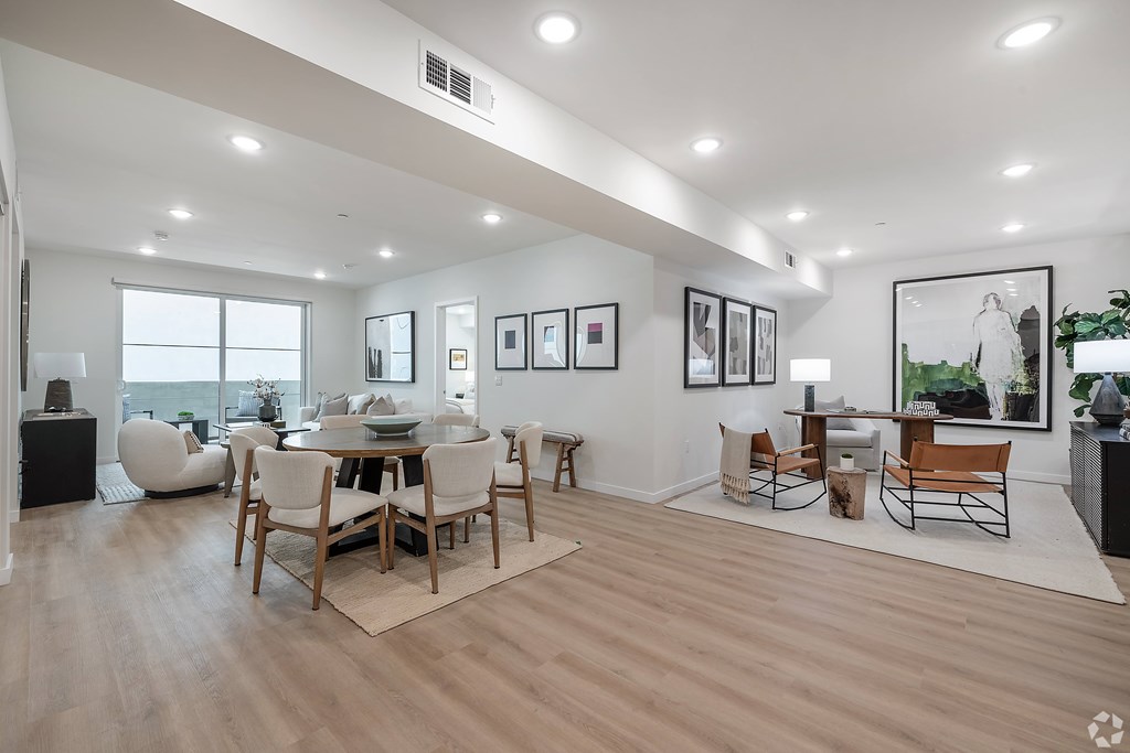 A modern living room with a dining table and chairs.