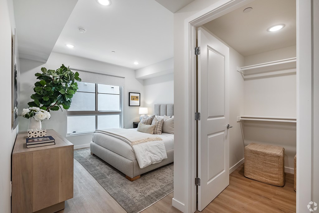 A bedroom with a large bed and a wooden nightstand.
