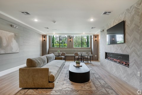 A modern living room with a fireplace and a large painting on the wall.