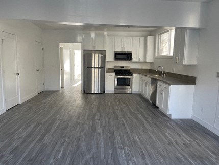 an empty kitchen with a stainless steel refrigerator