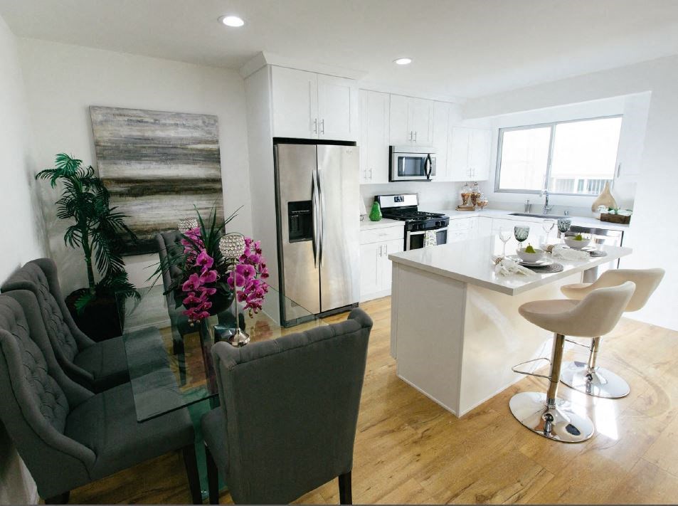 a kitchen and living room with a table and chairs