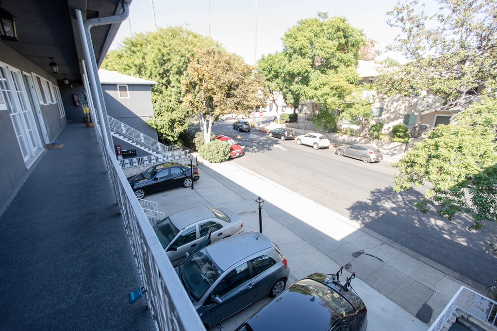 a balcony with a view of a street and cars parked on it