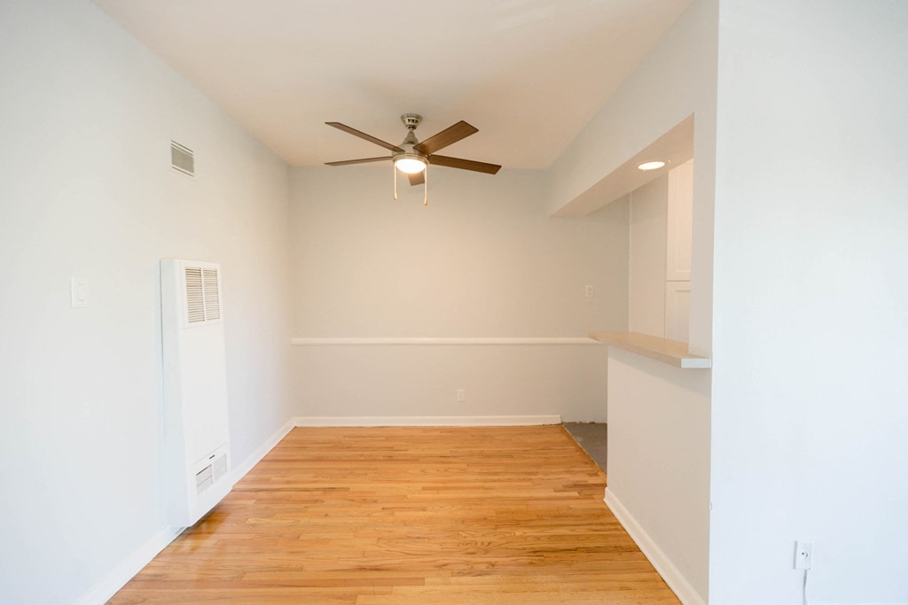 a living room with a ceiling fan and a wood floor