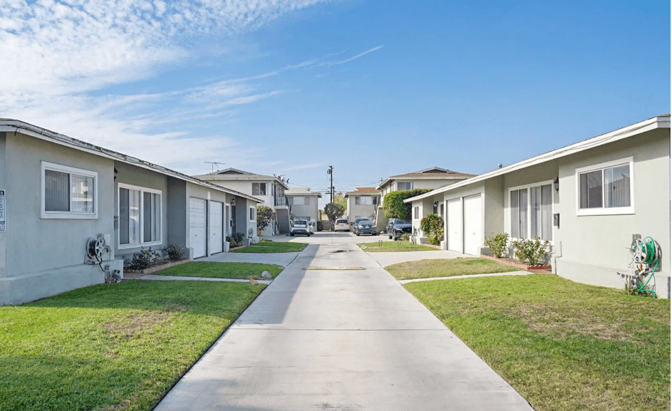 a row of houses on a street with a clear blue sky in the background