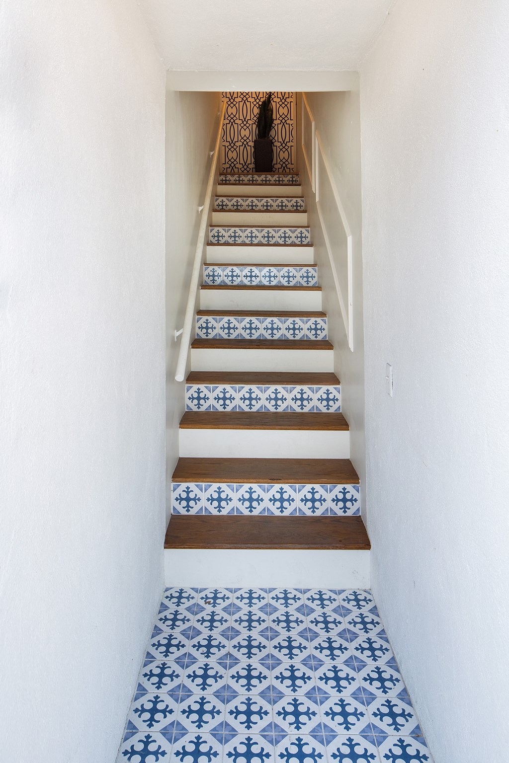 a staircase with blue and white tiles on the stairs