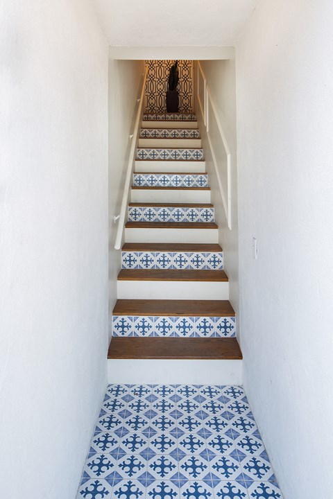 a staircase with blue and white tiles on the stairs