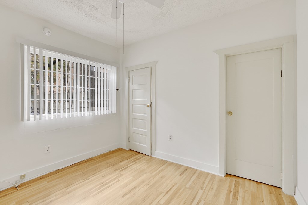 A room with a window and two doors.