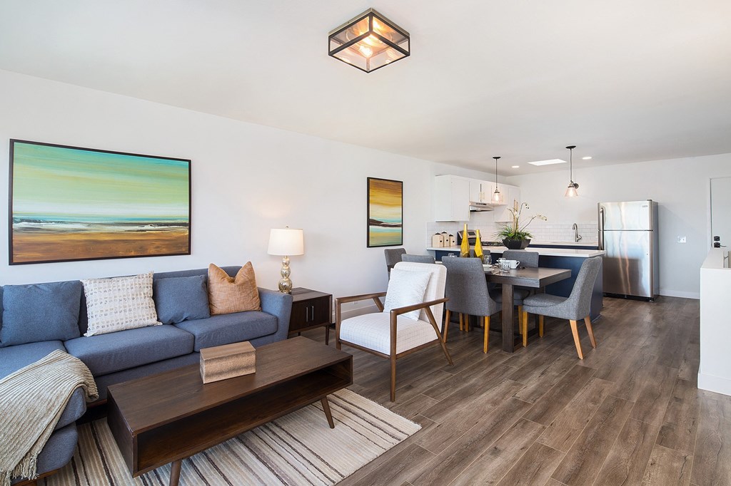 a living room with a blue couch and a dining room table