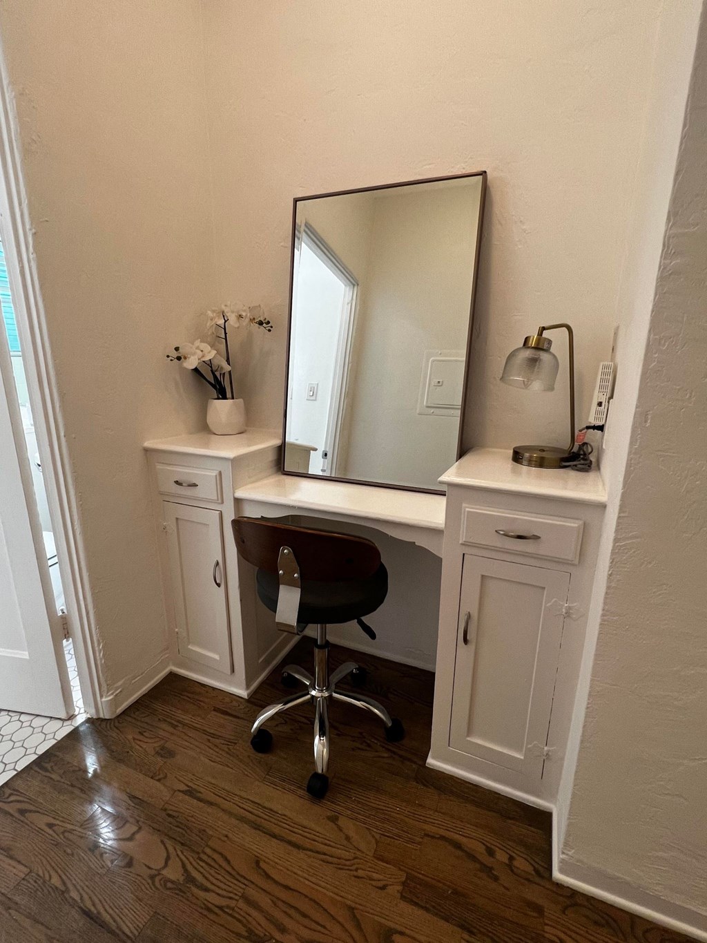 a desk with a mirror and a chair in a room