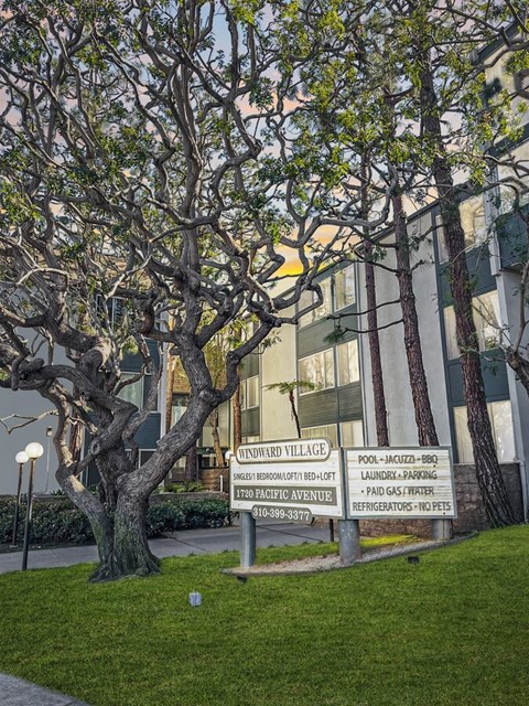 a sign in front of a building with trees