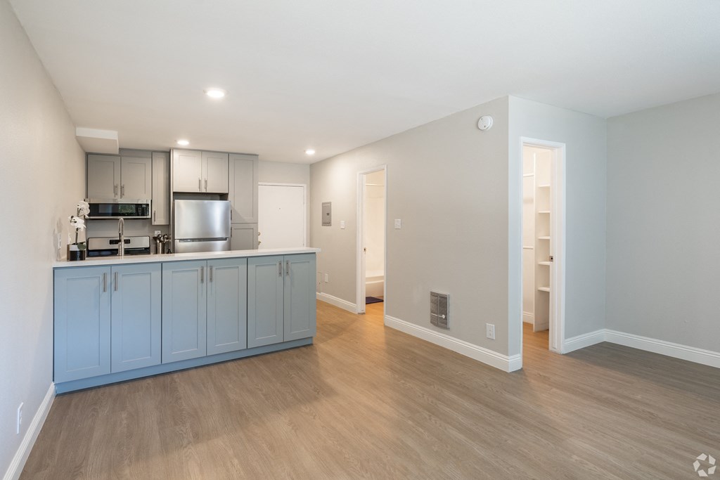 a kitchen and living room with blue cabinets and a wood floor