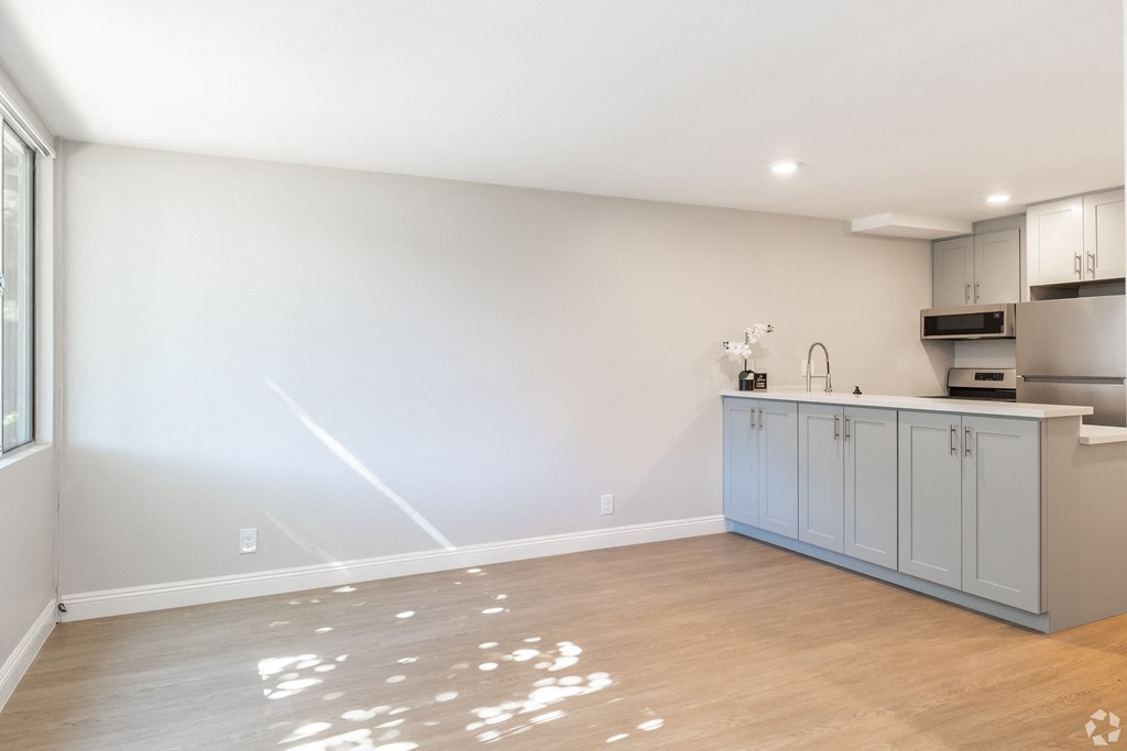 an empty kitchen with blue cabinets and a wood floor