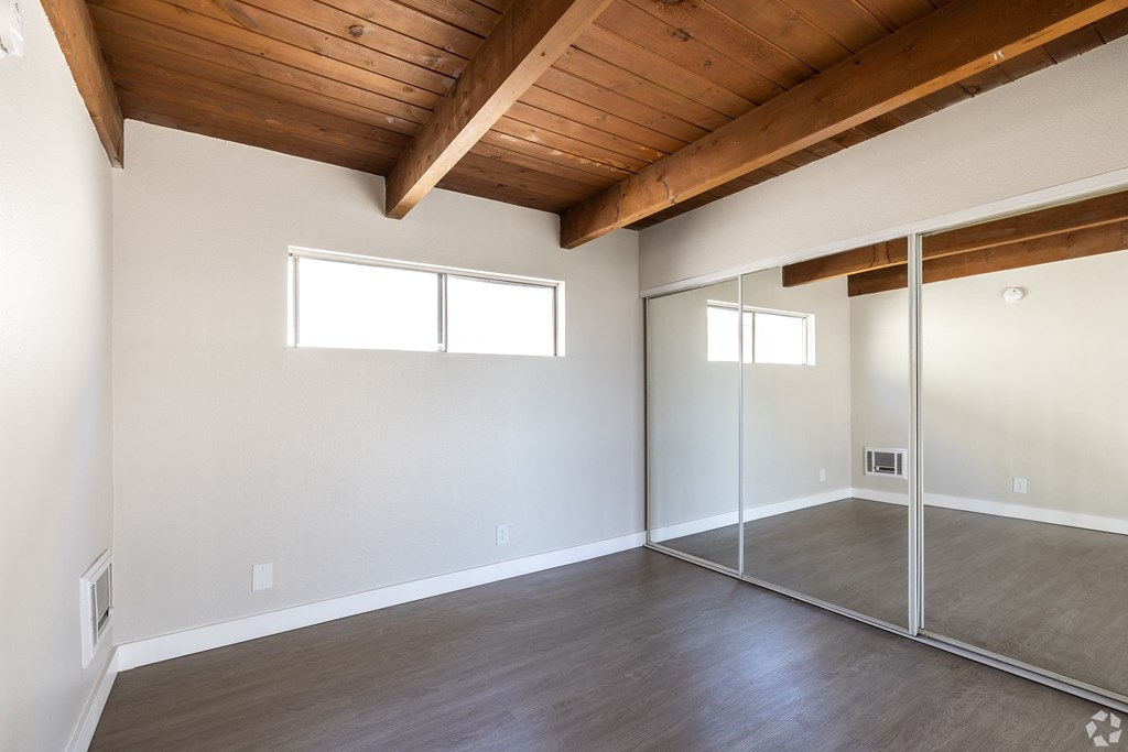 an empty living room with sliding glass doors to a closet