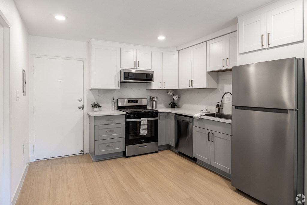a renovated kitchen with stainless steel appliances and white cabinets