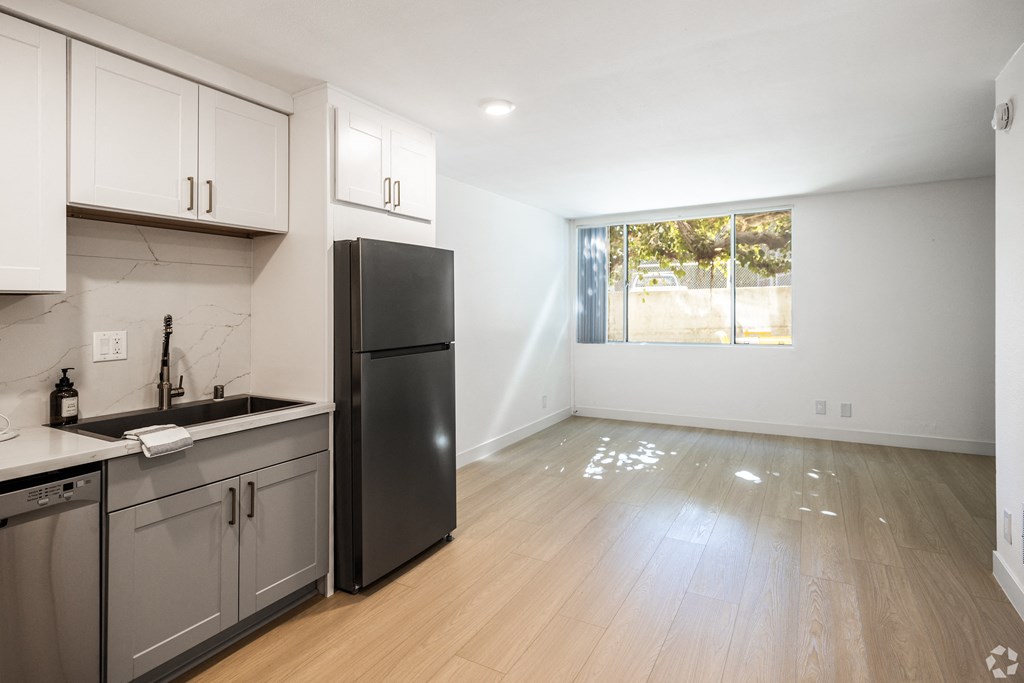 an empty kitchen with stainless steel appliances and a window