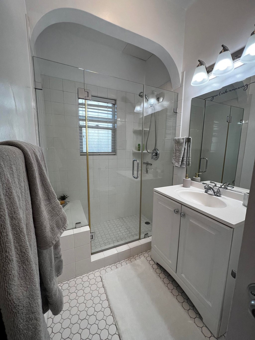 a bathroom with a shower and a sink and a mirror