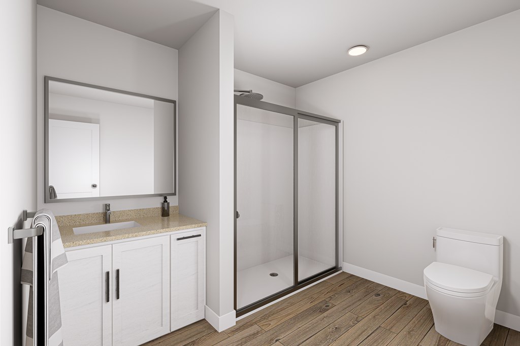 A white bathroom with a sink, mirror, toilet and shower.