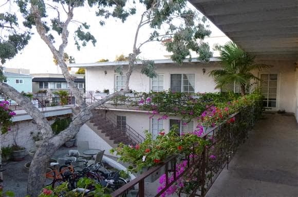 a house with a balcony and a tree