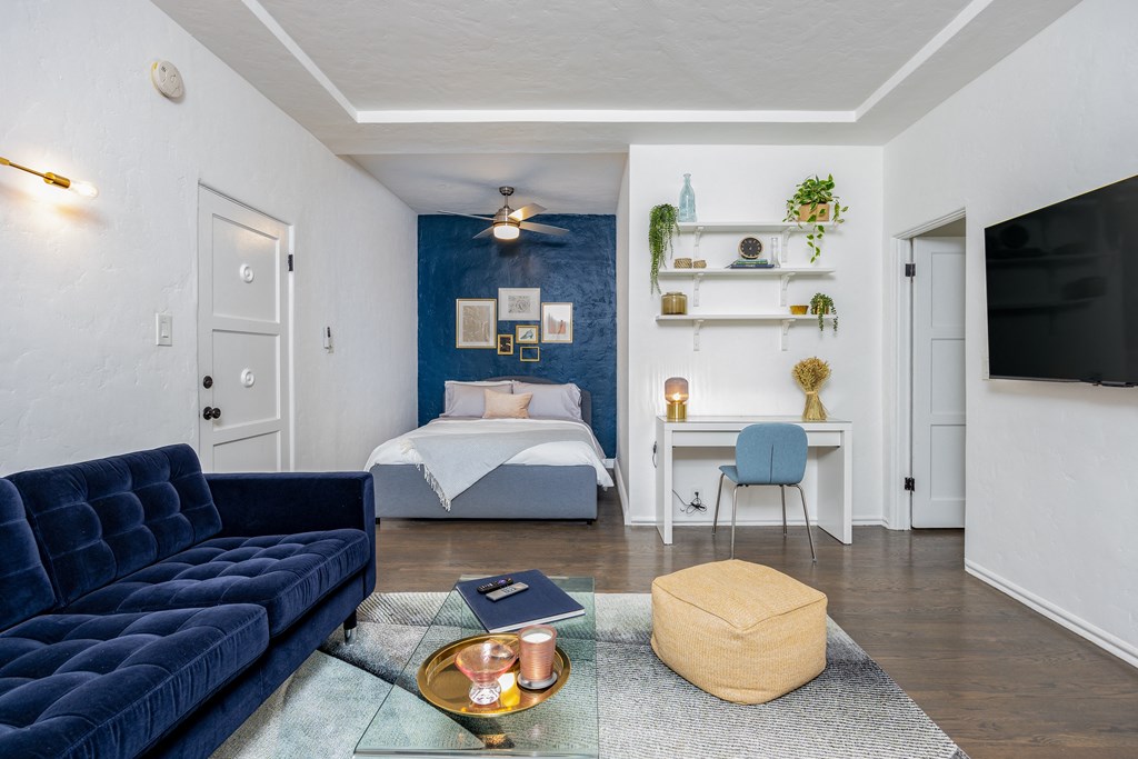 a bedroom with a bed and a desk in a room