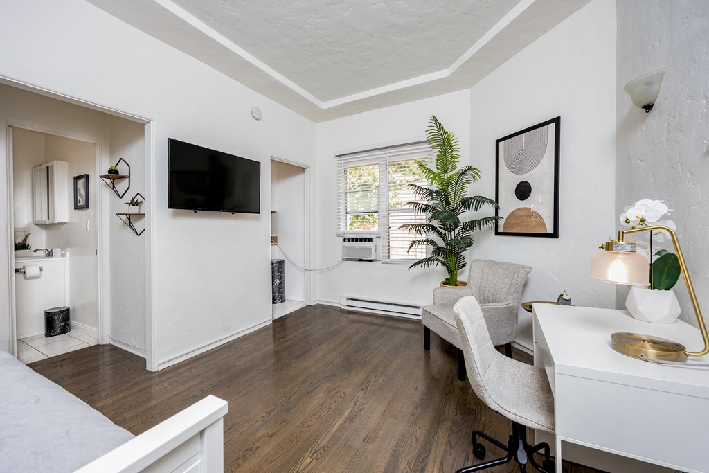 a living room with hardwood floors and white walls