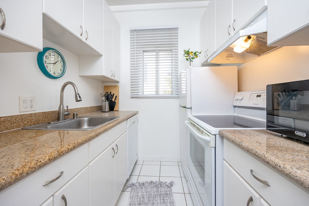 a kitchen with white cabinets and granite countertops
