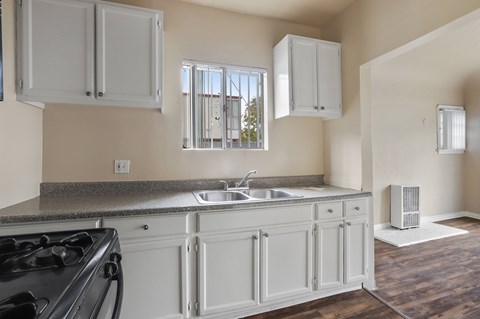 A kitchen with white cabinets and a black stove top.