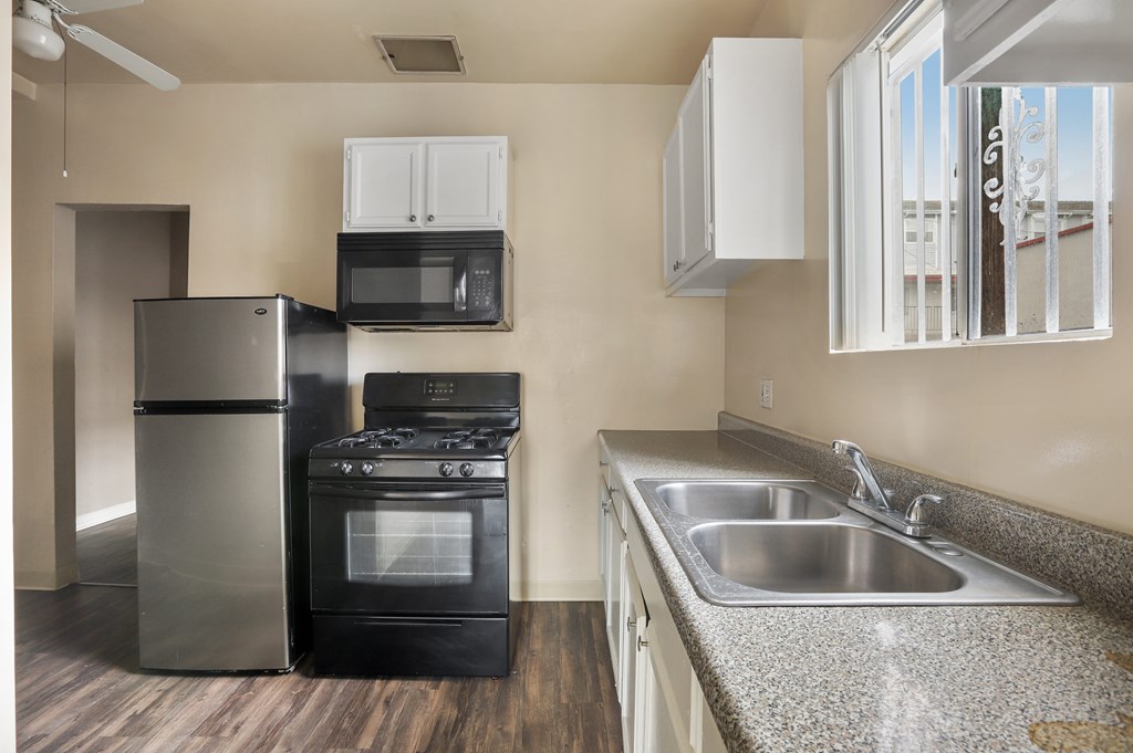 A kitchen with a stainless steel refrigerator, oven, and microwave.