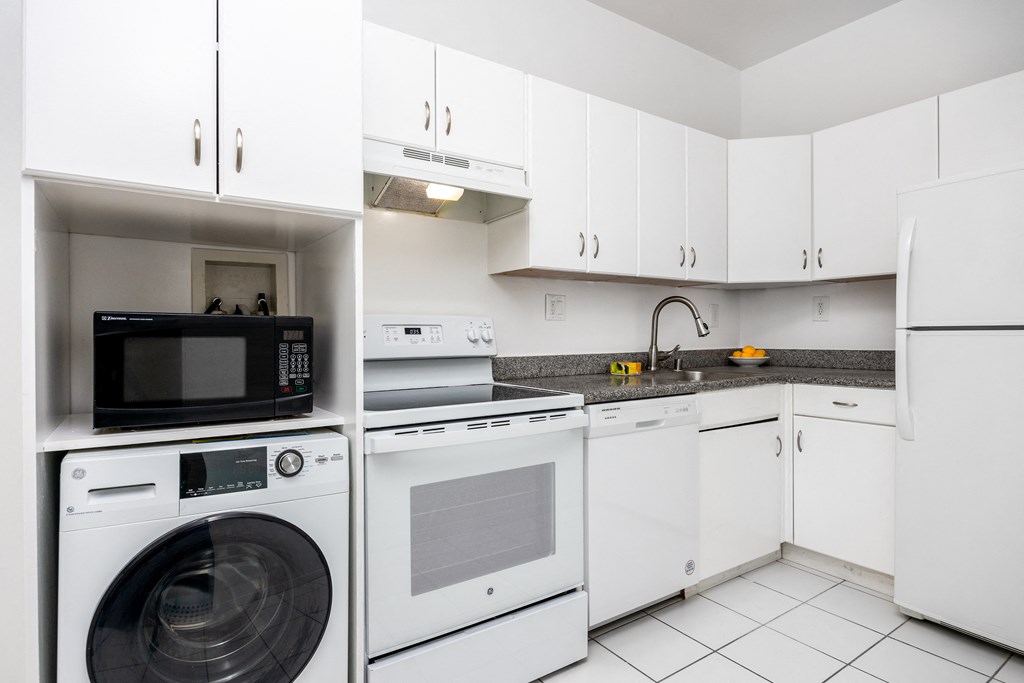 a kitchen with white cabinetry and a white tiled floor
