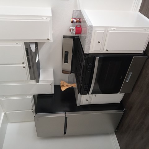 A white oven with a wooden spatula in it.